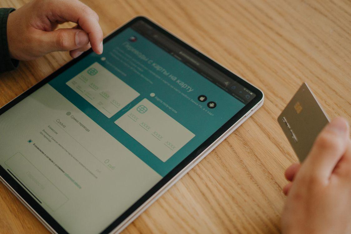 Person holding credit card making a direct hotel booking on tablet