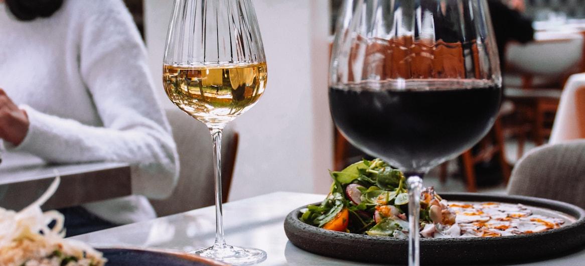 Woman dining at restaurant with wine — true cost of acquiring a restaurant diner 2026